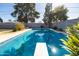 Backyard pool with diving board surrounded by greenery and block wall providing a serene and private outdoor retreat at 3511 E Elm St, Phoenix, AZ 85018