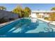 Backyard pool with view of the white house with a gray block fence, a serene and private outdoor space for relaxation at 3511 E Elm St, Phoenix, AZ 85018