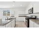 Beautiful kitchen with stainless appliances, granite countertops, island, and white cabinets at 39965 W Venture Rd, Maricopa, AZ 85138