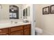 Well-lit bathroom with a wood vanity and mirror at 42578 W Rosalia Dr, Maricopa, AZ 85138