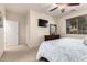 Bright bedroom featuring a patterned bedspread, ceiling fan, and mounted television at 42578 W Rosalia Dr, Maricopa, AZ 85138