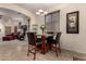 Charming dining area with a marble-top table and chairs, open to the living room and kitchen at 42578 W Rosalia Dr, Maricopa, AZ 85138