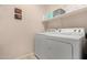 Laundry room with white washer and dryer and shelving for storage at 42578 W Rosalia Dr, Maricopa, AZ 85138