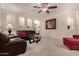 Comfortable living room with a ceiling fan, plush carpet, and leather sofas at 42578 W Rosalia Dr, Maricopa, AZ 85138