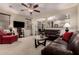 Cozy living room with leather sofas, ceiling fan, and open archway to the adjacent dining area at 42578 W Rosalia Dr, Maricopa, AZ 85138