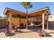 Inviting covered patio with a cozy seating area, hammock, and beautiful plants at 42578 W Rosalia Dr, Maricopa, AZ 85138