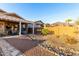 Well-kept backyard with covered patio, desert landscaping, a rock stream, and picturesque mountain views at 4267 S Strong Box Rd, Gold Canyon, AZ 85118