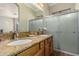 Bathroom with double sinks, granite countertop, wood cabinets, and a glass-enclosed shower at 4267 S Strong Box Rd, Gold Canyon, AZ 85118