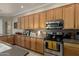 Bright kitchen area with stainless steel appliances, tiled floors and island sink at 4267 S Strong Box Rd, Gold Canyon, AZ 85118