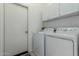 Well-lit laundry room features white washer and dryer set, white cabinets, and door to another part of the home at 4267 S Strong Box Rd, Gold Canyon, AZ 85118