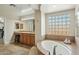 Elegant bathroom featuring a soaking tub, vanity with seating, and custom tiled accents at 4502 E Night Owl Ln, Cave Creek, AZ 85331