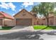 Charming tan stucco home with a brown garage door, red tile roof, and green lawn at 4683 W Dublin St, Chandler, AZ 85226