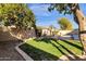 View of backyard showing lawn, mature landscaping, seating, a water feature and a fenced in in-ground pool at 474 E Baylor Ln, Gilbert, AZ 85296