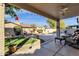 Outdoor patio area with seating offering a view of the pool in the backyard and a well manicured lawn at 474 E Baylor Ln, Gilbert, AZ 85296