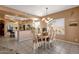 Dining area featuring a table with seating, an elegant light fixture, and an open view into the kitchen at 474 E Baylor Ln, Gilbert, AZ 85296