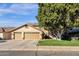 Beautiful home with a two-car garage, complemented by a lush lawn and mature tree at 474 E Baylor Ln, Gilbert, AZ 85296