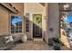 Welcoming front porch with a decorated front door, a comfortable bench and potted plants at 474 E Baylor Ln, Gilbert, AZ 85296