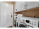 Well-lit laundry room featuring washer, dryer, overhead cabinets and a door to the exterior at 474 E Baylor Ln, Gilbert, AZ 85296