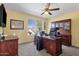 A bright office space featuring custom cabinetry, a ceiling fan, and a large window for natural light at 474 E Baylor Ln, Gilbert, AZ 85296