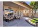 Covered outdoor patio area with comfortable seating and a view of the landscaped backyard at 474 E Baylor Ln, Gilbert, AZ 85296