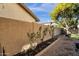 Side yard featuring a gravel path, a small garden with decorative plants, and a privacy wall at 474 E Baylor Ln, Gilbert, AZ 85296