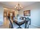 Elegant dining room featuring a dark wood table, chandelier, and artwork, open to the kitchen at 518 E Laddoos Ave, Queen Creek, AZ 85140