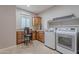 Functional laundry room with a built-in desk area, ample storage, and modern appliances for added convenience at 518 E Laddoos Ave, Queen Creek, AZ 85140