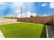 View of the backyard featuring artificial turf and a privacy wall at 5281 S Red Rock St, Gilbert, AZ 85298