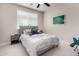 Cozy bedroom with neutral tones, a ceiling fan, window with blinds, and framed landscape art for a serene ambiance at 5281 S Red Rock St, Gilbert, AZ 85298