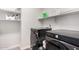 Modern laundry room showcasing front load washer and dryer with storage shelving at 5281 S Red Rock St, Gilbert, AZ 85298