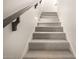 Carpeted stairs with sleek metal handrail and decorative wall lighting at 5281 S Red Rock St, Gilbert, AZ 85298