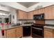 Functional kitchen with wood cabinets, neutral countertops, and modern black appliances at 5802 E Fountain St, Mesa, AZ 85205