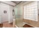 Bathroom with a shower enclosed in translucent glass, a tiled interior, and a contrasting wooden shower mat at 5802 E Fountain St, Mesa, AZ 85205