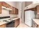 A kitchen featuring wooden cabinets, a white refrigerator, and a black and white stove top at 653 S Catalina St, Gilbert, AZ 85233