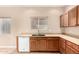 Kitchen area showcasing wood cabinets, counter space, a stainless steel sink, and a dishwasher at 653 S Catalina St, Gilbert, AZ 85233