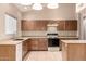 Functional kitchen featuring wood cabinets, laminate countertops, and standard appliances at 653 S Catalina St, Gilbert, AZ 85233