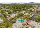 An aerial view of the community shows the pool, mature trees, landscaping, and mountain views in the background at 6542 N 7Th Ave # 30, Phoenix, AZ 85013