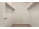 Walk-in closet showing built-in shelving and updated carpet at 6542 N 7Th Ave # 30, Phoenix, AZ 85013