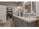 Updated bathroom features a dual sink vanity with gray cabinetry, granite counters, and ceramic tile flooring at 6881 W Greenbriar Dr, Glendale, AZ 85308