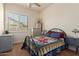 Cozy bedroom featuring a quaint window, neutral walls, plush carpeting, and a custom quilt at 6881 W Greenbriar Dr, Glendale, AZ 85308