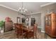 Dining room showcasing modern chandelier, wood table and chairs, and decor pieces at 6881 W Greenbriar Dr, Glendale, AZ 85308