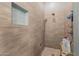 Stylish walk-in shower featuring ceramic tile walls, a rainfall shower head and built-in toiletry storage at 6881 W Greenbriar Dr, Glendale, AZ 85308