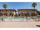 Community pool area surrounded by townhouses, palm trees, lounge chairs, and a secure fence at 710 S Beck Ave, Tempe, AZ 85281