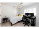 Comfortable bedroom features a ceiling fan, a window with shutters, and space for a home office setup at 710 S Beck Ave, Tempe, AZ 85281