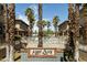 Community entrance with brick sign and lush palm trees, showcasing well-maintained townhouses and pool at 710 S Beck Ave, Tempe, AZ 85281