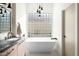 Bathroom featuring a freestanding tub, modern fixtures, sleek design, and natural light from the window at 9246 N 108Th St, Scottsdale, AZ 85259