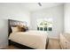 Sunlit bedroom with a queen bed, shuttered windows, and hardwood floors at 9246 N 108Th St, Scottsdale, AZ 85259