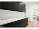 Modern kitchen featuring sleek black cabinetry, white countertops, and minimalist hardware at 9246 N 108Th St, Scottsdale, AZ 85259