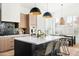 This modern kitchen features wooden cabinets, black countertops, a center island and stylish light fixtures at 9246 N 108Th St, Scottsdale, AZ 85259