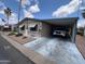 Charming single-story home with an attached carport, landscaped yard and beautiful blue skies at 9302 E Broadway Rd # 64, Mesa, AZ 85208